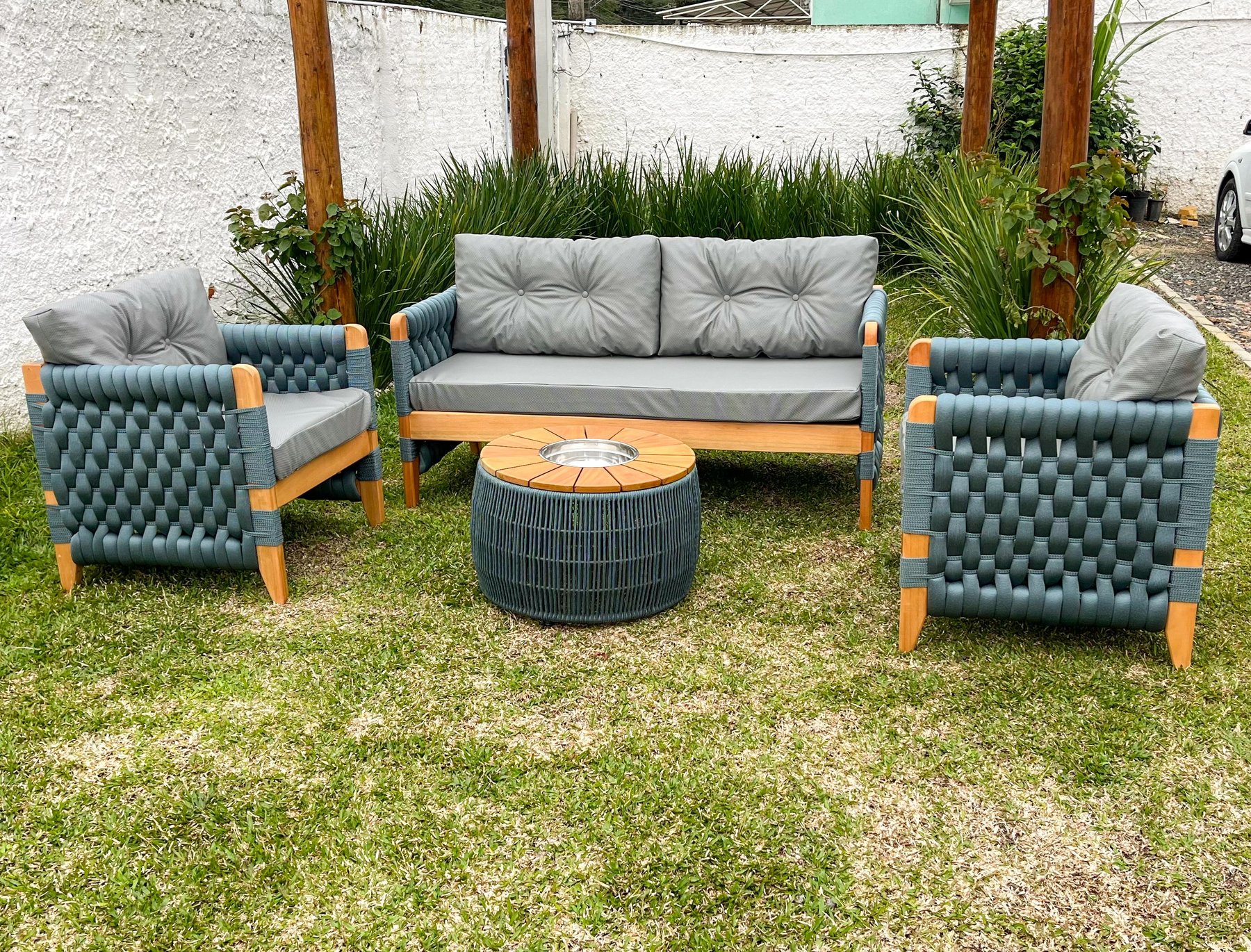 Sofá e poltronas em madeira com trama azul e mesa de centro