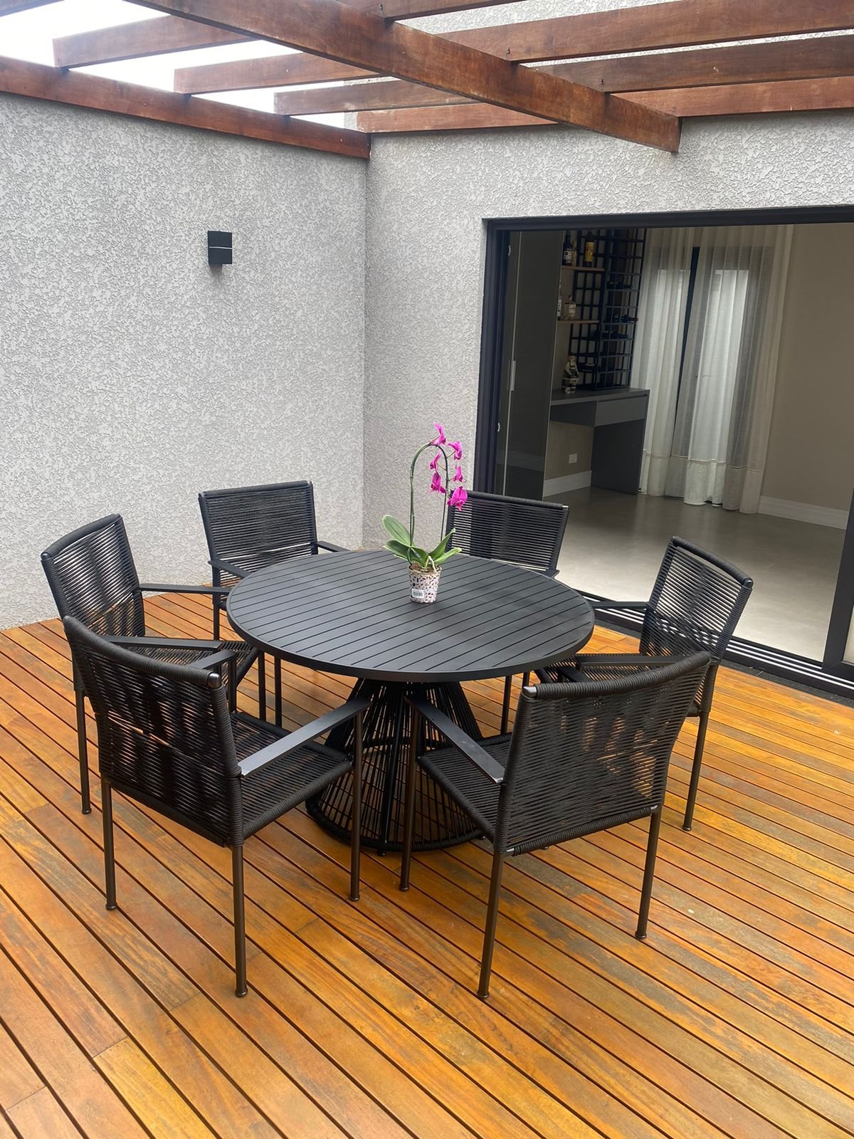 Conjunto de jantar preto em corda náutica sobre deck de madeira