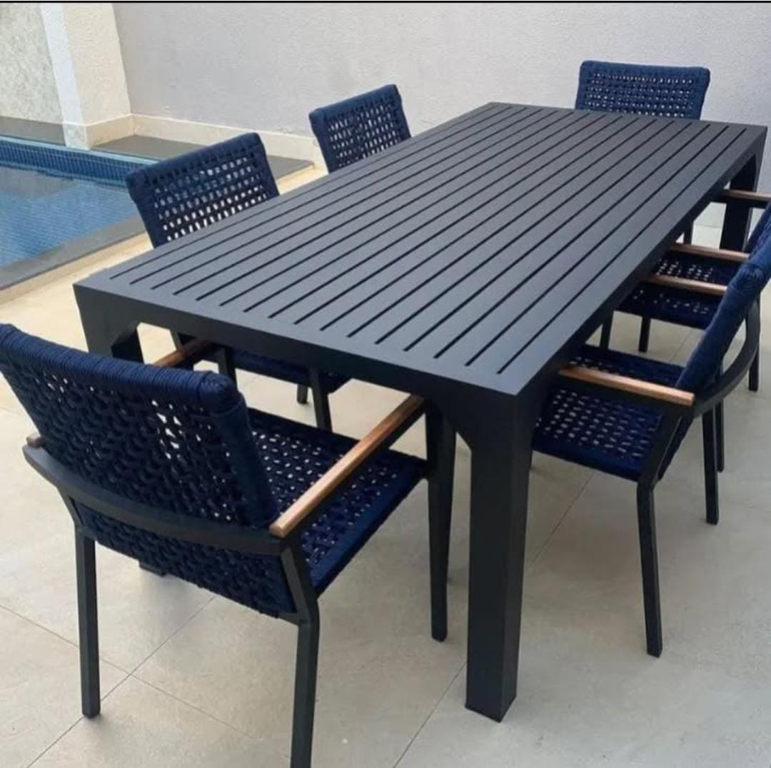 Conjunto jantar ripado preto com cadeiras em corda náutica azul ao lado da piscina